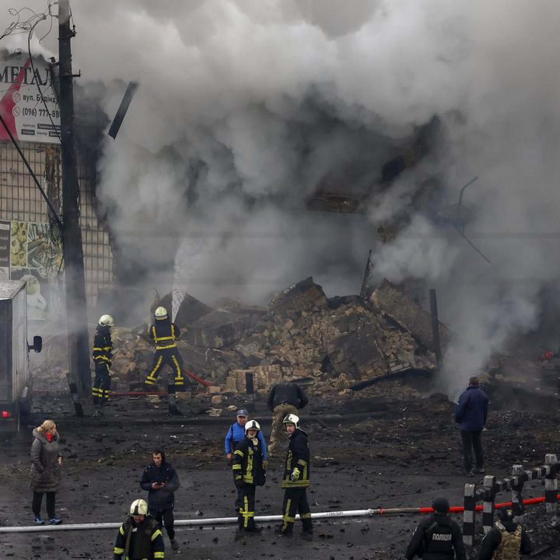 Fire and rescue workers attend a building hit by a missile in central Kyiv