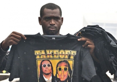 A fan holds up a shirt honouring Takeoff as he stands in linefor the memorial service