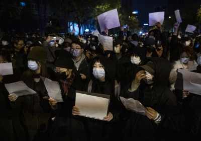 Demonstrators in Beijing hold blank pieces of paper