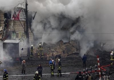 Fire and rescue workers attend a building hit by a missile in central Kyiv